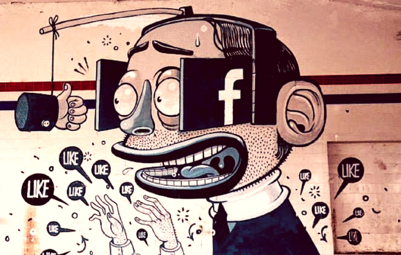 Street mural of a man whose eyes are covered by phone screens showing the Facebook logo, chasing a carrot on a stick while 'LIKE' speech bubbles swarm around him